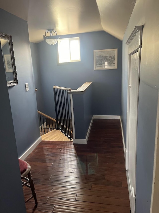 hall featuring dark hardwood / wood-style flooring and vaulted ceiling