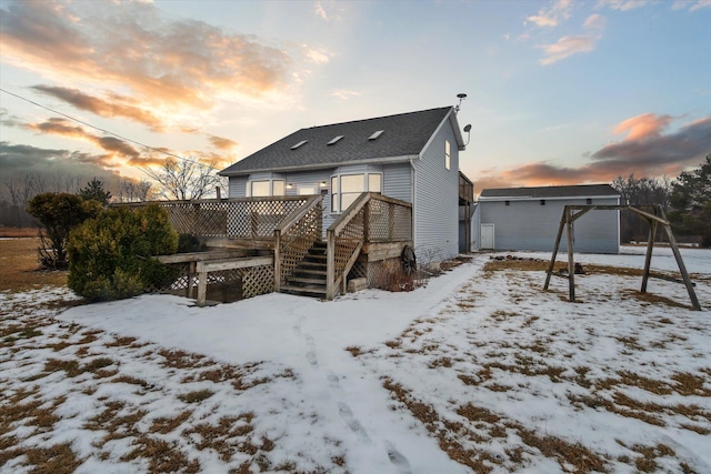 snow covered back of property featuring a wooden deck