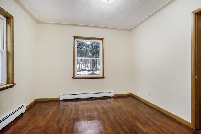 empty room featuring a baseboard radiator, dark wood-type flooring, and a textured ceiling