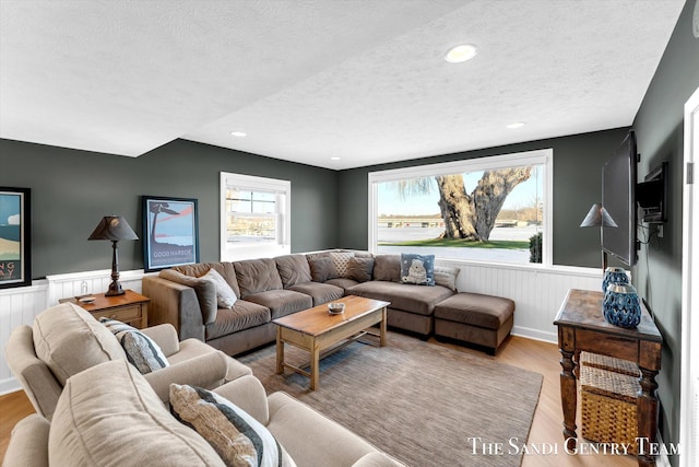 living area featuring a wainscoted wall, a textured ceiling, wood finished floors, and recessed lighting