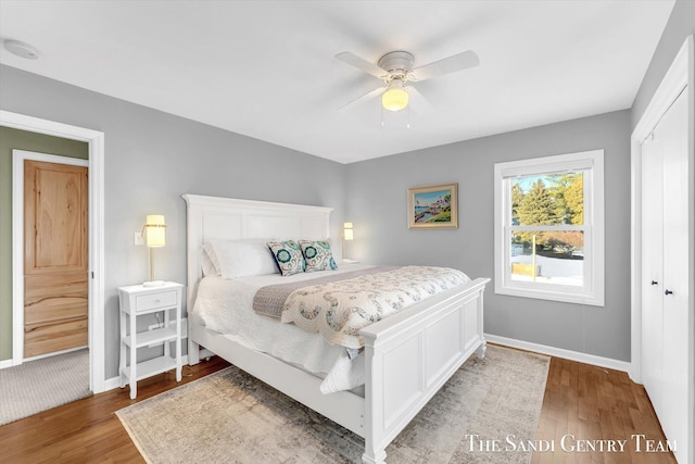 bedroom featuring a ceiling fan, baseboards, and wood finished floors