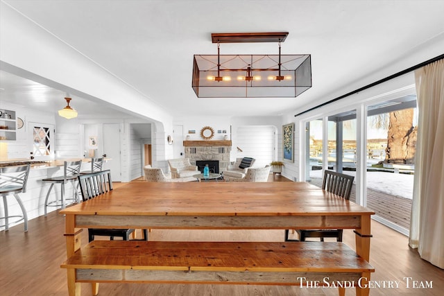 dining area with a fireplace and wood finished floors