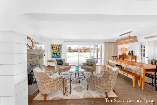 living area featuring french doors, a fireplace, and wood finished floors