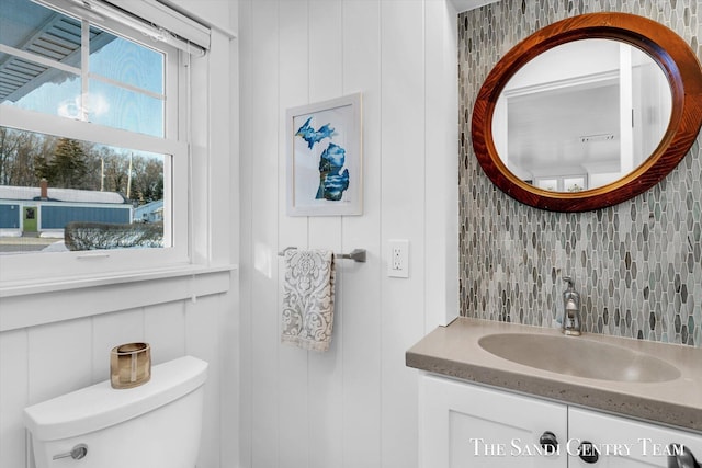 bathroom featuring vanity, backsplash, and toilet