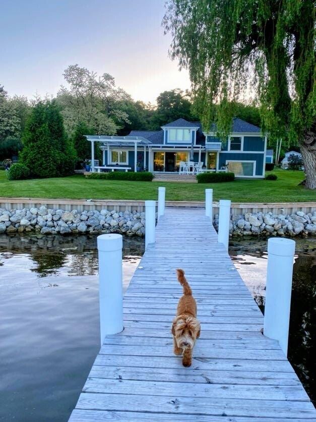 view of dock with a water view and a lawn