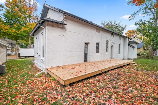 view of property exterior with a yard and a deck