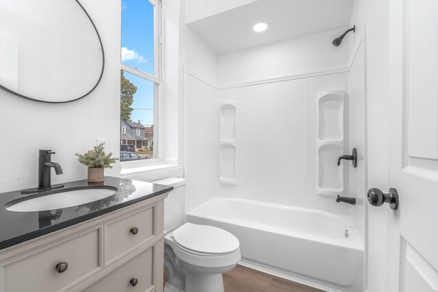 full bathroom with vanity, hardwood / wood-style floors, shower / bathtub combination, and toilet