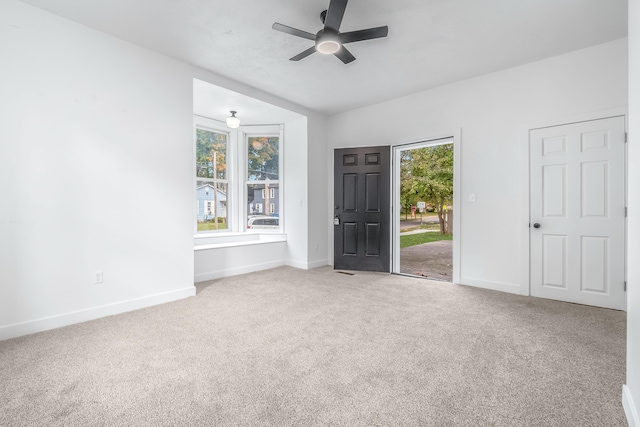 empty room featuring ceiling fan, carpet flooring, and a wealth of natural light