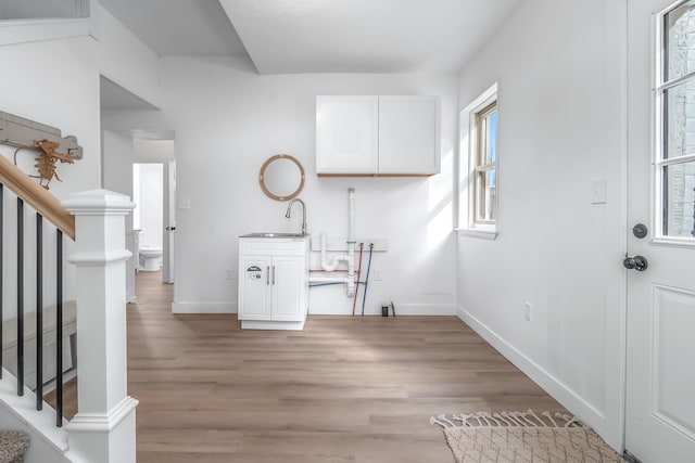 laundry room featuring sink and light hardwood / wood-style flooring