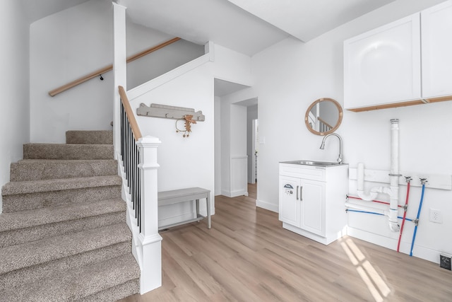 stairs with wood-type flooring and sink