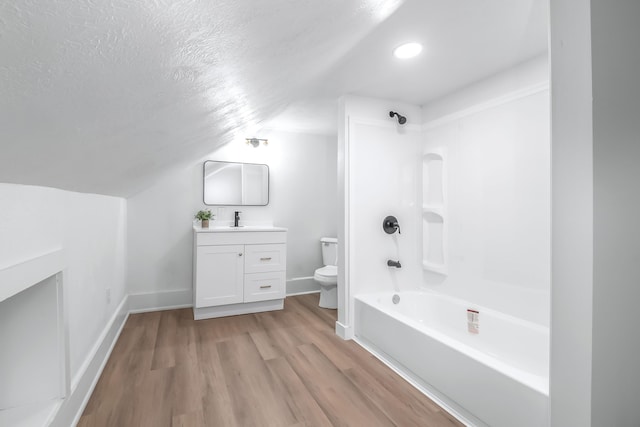 full bathroom featuring toilet, tub / shower combination, vaulted ceiling, a textured ceiling, and hardwood / wood-style flooring