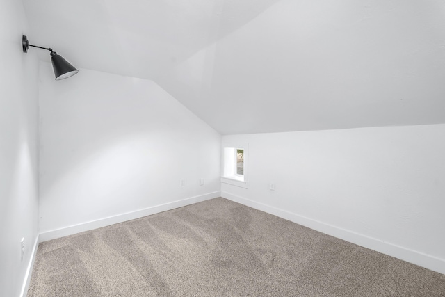 bonus room featuring lofted ceiling and carpet flooring