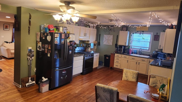 kitchen featuring white cabinetry, black range with gas stovetop, sink, and stainless steel fridge with ice dispenser