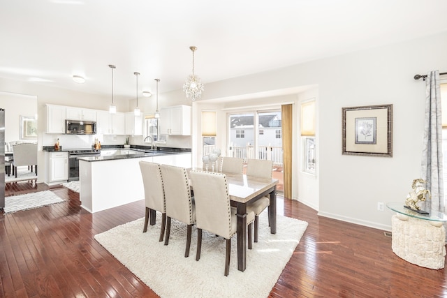 dining room featuring dark hardwood / wood-style floors, sink, and a notable chandelier