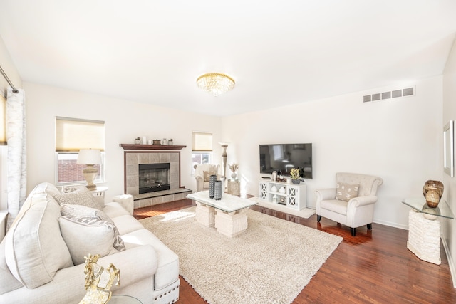 living room featuring dark hardwood / wood-style flooring and a tile fireplace