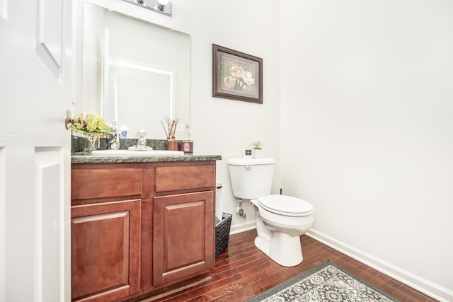 bathroom with hardwood / wood-style flooring, vanity, and toilet