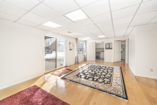 living room featuring hardwood / wood-style floors and a drop ceiling