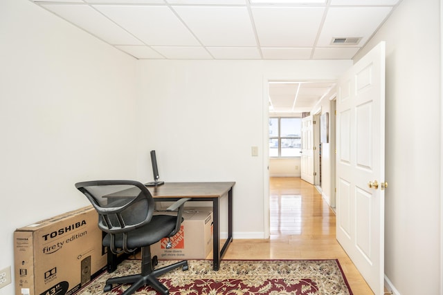 home office featuring a drop ceiling and light hardwood / wood-style flooring