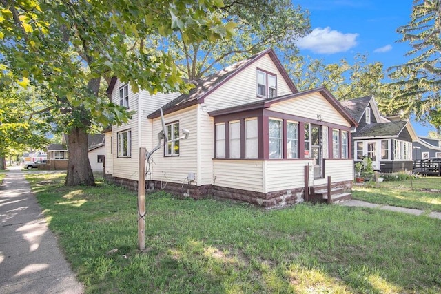 view of property exterior featuring a sunroom and a yard