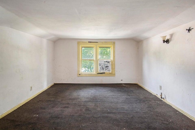 carpeted spare room with lofted ceiling