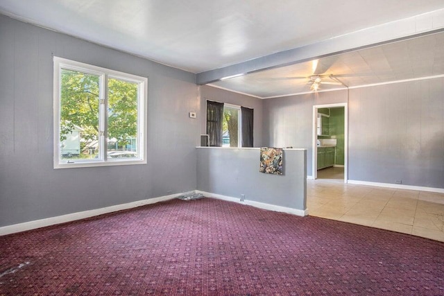 carpeted empty room featuring beamed ceiling