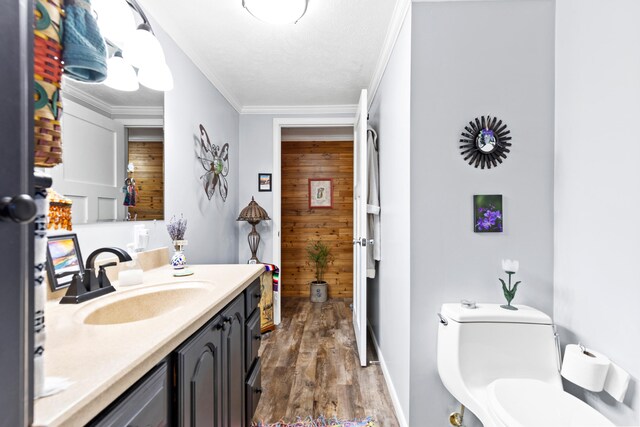 3509 N Shore Dr, Sears, MI 49679 - bathroom featuring vanity, toilet, wood walls, wood finished floors, and ornamental molding