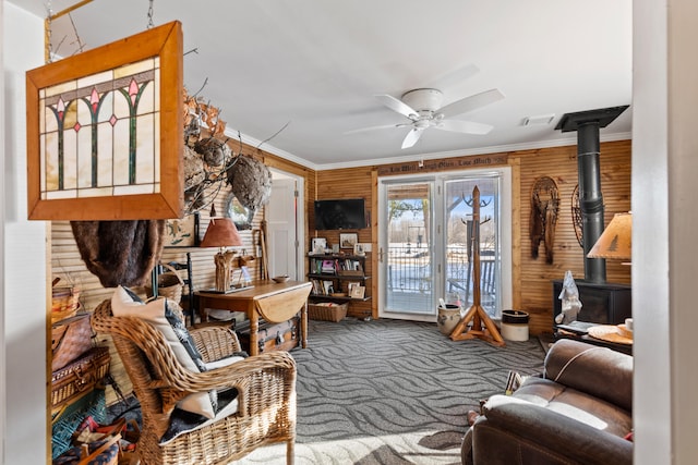 3509 N Shore Dr, Sears, MI 49679 - carpeted living area featuring a ceiling fan, visible vents, ornamental molding, and a wood stove