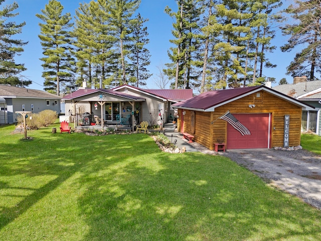 3509 N Shore Dr, Sears, MI 49679 - view of front facade with a porch, a detached garage, a front yard, and metal roof