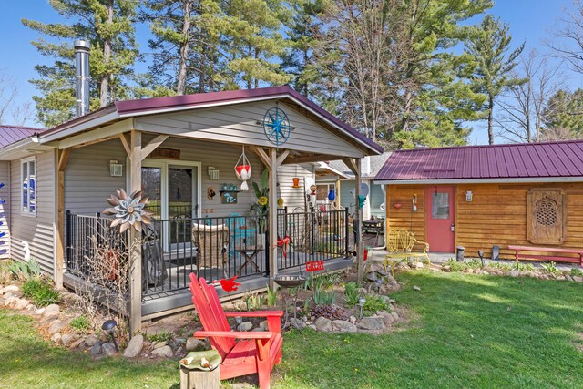 3509 N Shore Dr, Sears, MI 49679 - view of front of house with a front lawn, covered porch, and metal roof