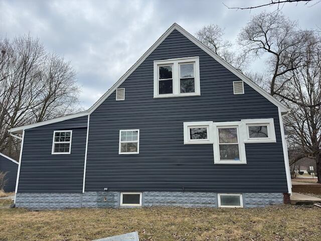 view of side of home with a yard