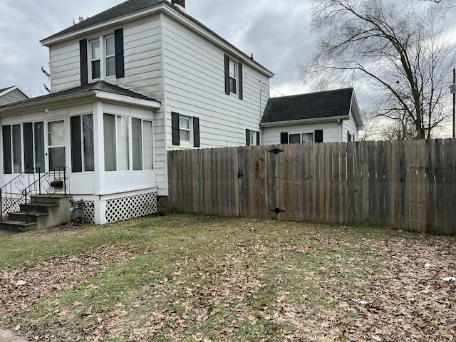 view of side of home with a yard and a sunroom