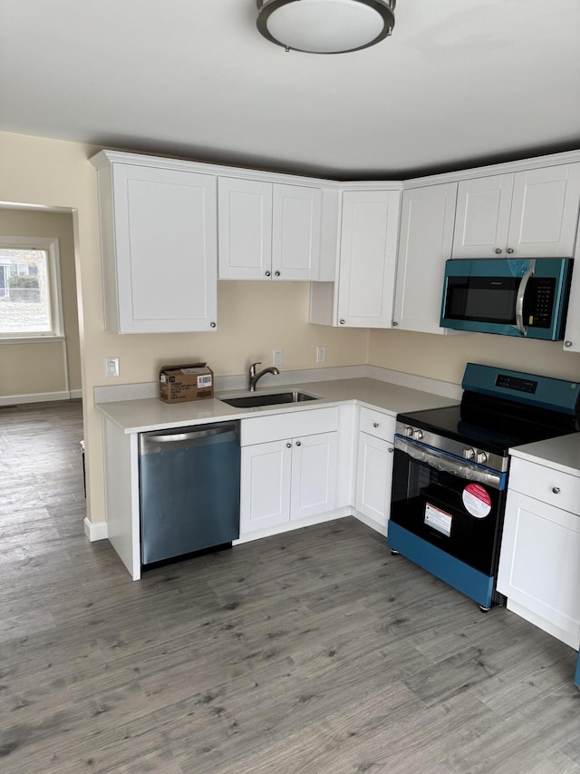 kitchen featuring white cabinetry, sink, stainless steel appliances, and hardwood / wood-style floors