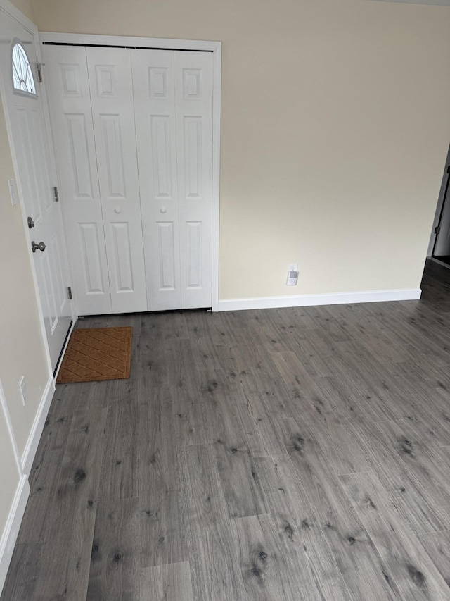 unfurnished bedroom with dark wood-type flooring and a closet