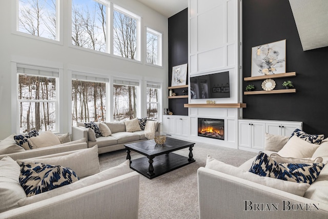 living room with built in features, carpet, and a high ceiling