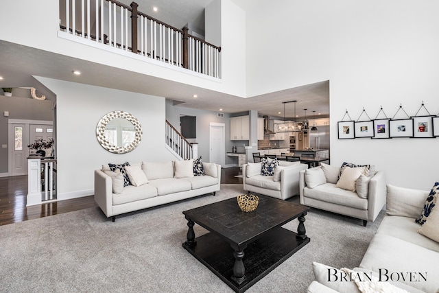 living room featuring a towering ceiling and wood-type flooring