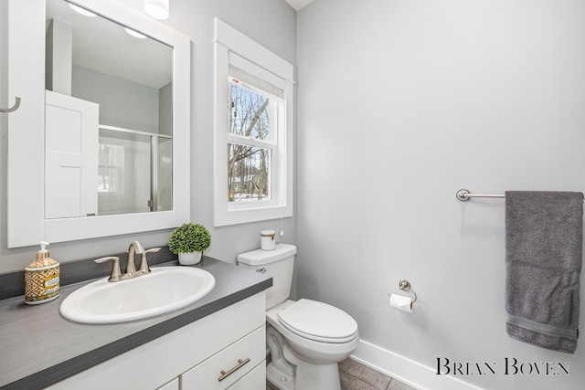 bathroom with tile patterned flooring, vanity, an enclosed shower, and toilet