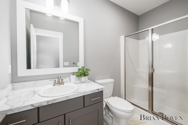 bathroom featuring vanity, toilet, and a shower with shower door