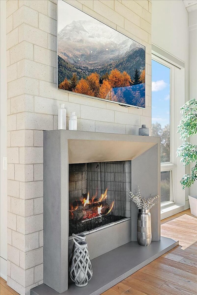 details with hardwood / wood-style flooring and a brick fireplace