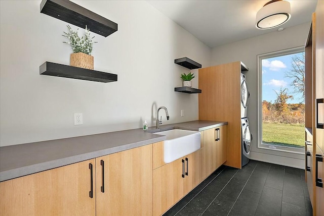 interior space with stacked washer and dryer, sink, and light brown cabinets