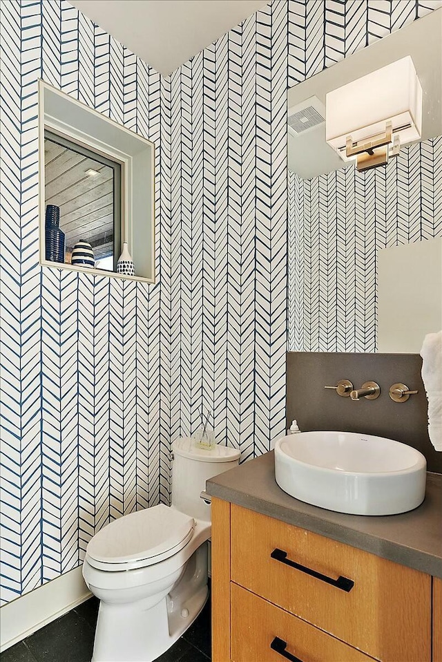 bathroom with tile patterned flooring, vanity, tile walls, and toilet