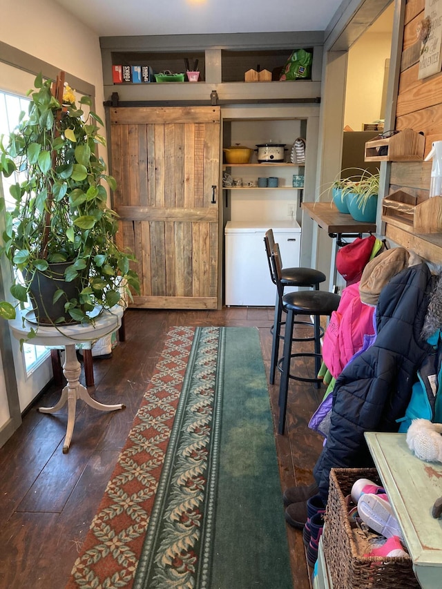 interior space with dark hardwood / wood-style floors and a barn door