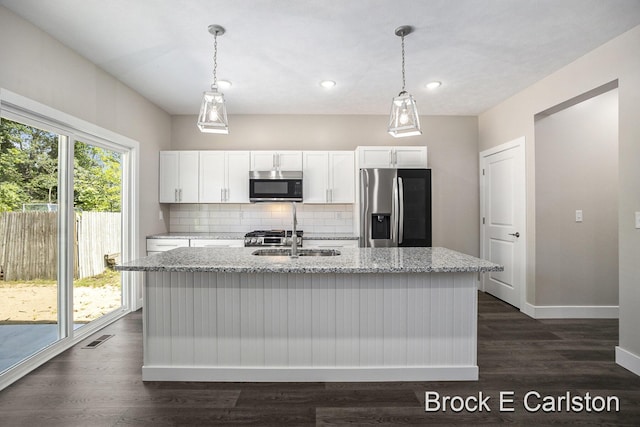 kitchen featuring stainless steel appliances, decorative light fixtures, sink, and white cabinets