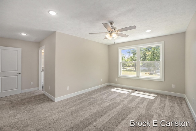 unfurnished room with ceiling fan, carpet floors, and a textured ceiling