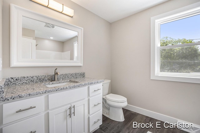 bathroom with hardwood / wood-style flooring, vanity, and toilet