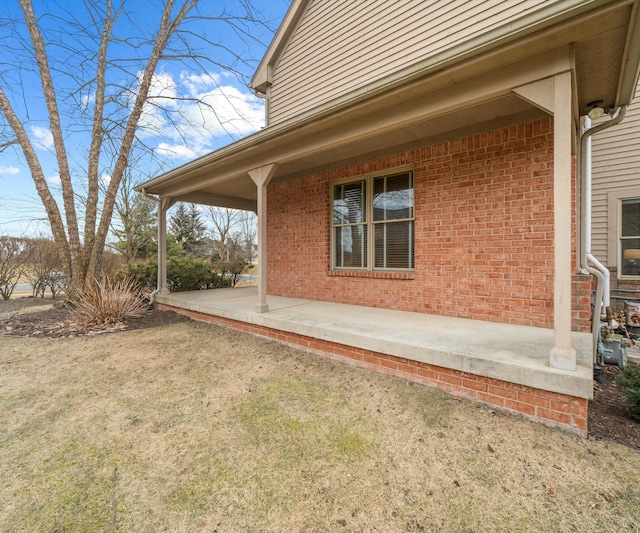 view of side of property featuring a patio and a lawn