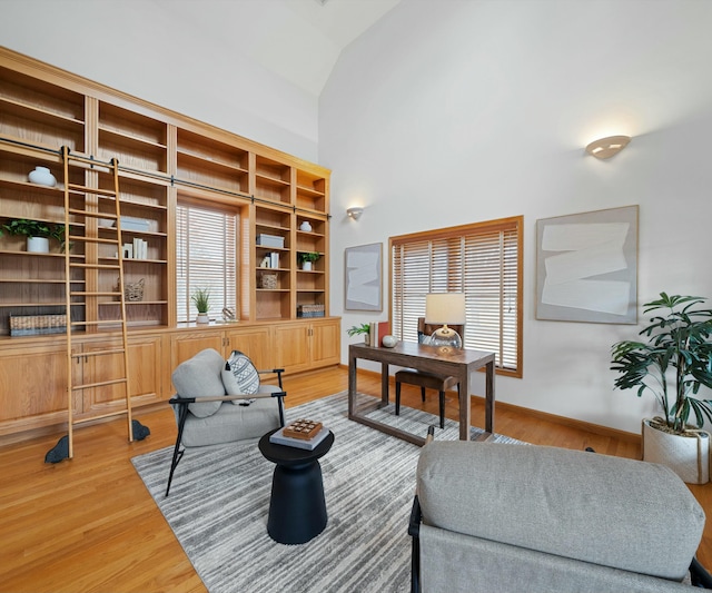 office space featuring high vaulted ceiling, a healthy amount of sunlight, and hardwood / wood-style floors