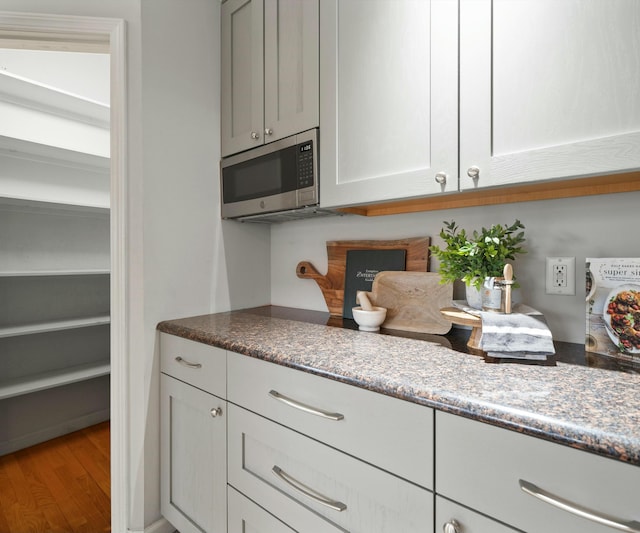 kitchen with wood-type flooring and stone countertops