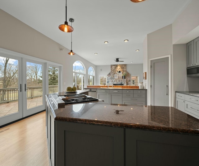 kitchen featuring gray cabinets, pendant lighting, dark stone counters, and stainless steel appliances