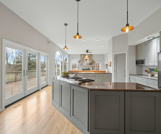 kitchen featuring french doors, appliances with stainless steel finishes, hanging light fixtures, and gray cabinetry