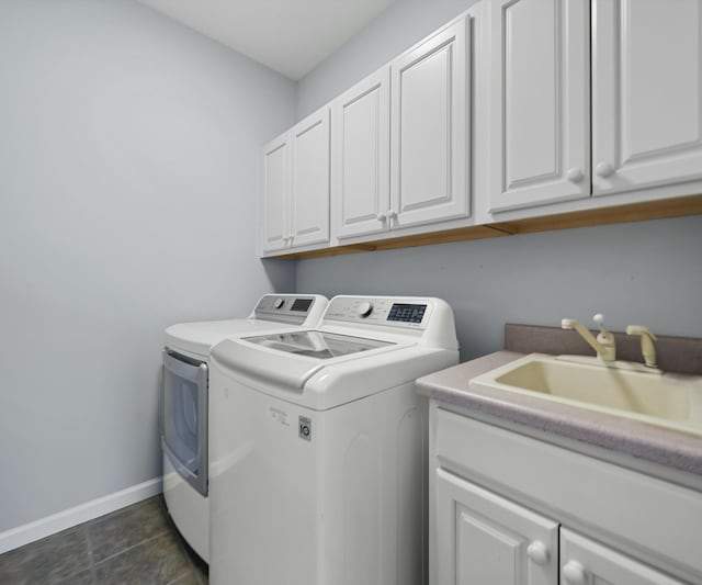 washroom featuring sink, washer and clothes dryer, cabinets, and dark tile patterned flooring